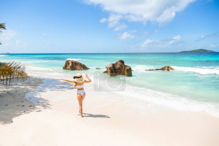 Téléchargez les photos : Femme en bikini élégant profitant d'une promenade sur l'île des Seychelles. Vacances d'été. Espace de copie - en image libre de droit