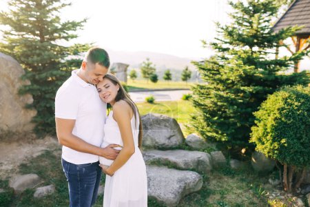 Téléchargez les photos : Un beau jeune couple marié se tient près de la pierre et s'étreint doucement. - en image libre de droit
