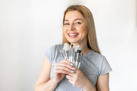 Photo for Portrait of the beautiful woman with make-up brushes near attractive face with natural make up - Royalty Free Image