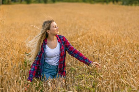 Téléchargez les photos : Belle jeune femme sur le champ de blé d'été. Espace de copie - en image libre de droit