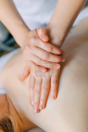 Téléchargez les photos : Mains de masseur professionnel faisant massage du dos dans le spa de bien-être, concept de traitement, gros plan - en image libre de droit