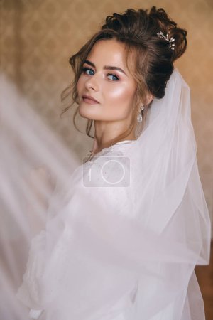 Photo for Attractive bride plays with a veil in the morning before the ceremony. - Royalty Free Image