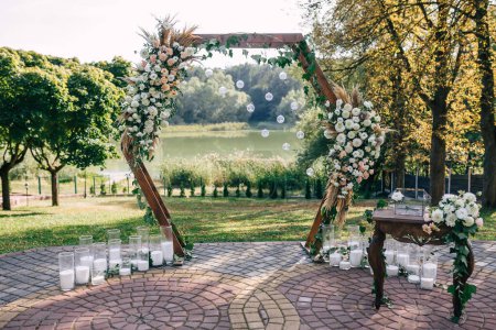 Téléchargez les photos : Cérémonie de mariage sur la rive du lac, arche avec des fleurs, mariage sur la rive du lac, décor - en image libre de droit
