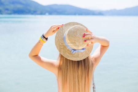 Téléchargez les photos : Jeune femme se détendre sur le beau lac, concept de vacances. fille tenant la main sur le plaisancier avec ruban adhésif - en image libre de droit