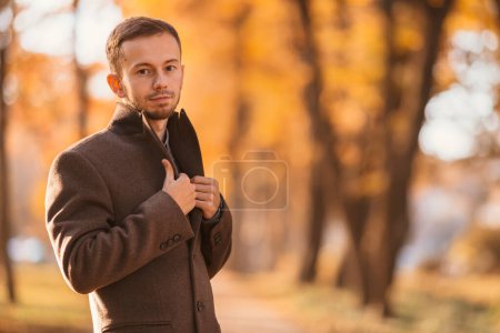 Photo for Handsome young man walking in the autumn park. - Royalty Free Image