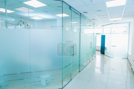 Photo for Interior of a stylish and clean modern hospital corridor with white walls, glass door. - Royalty Free Image
