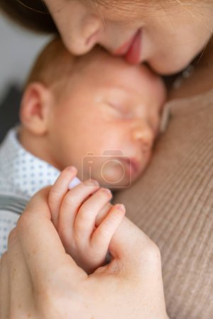 Téléchargez les photos : Mère tenant la main de dormir son bébé en gros plan, Nouveau concept famille et bébé - en image libre de droit