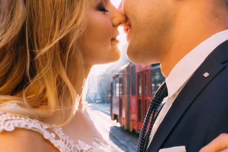 Foto de Primeros besos de recién casados y tranvía entre ellos. calle de ciudad. - Imagen libre de derechos
