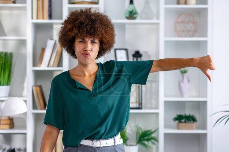 Photo for Unhappy African American lady showing thums down. Disappointed young black woman giving thumb down with hands - Royalty Free Image
