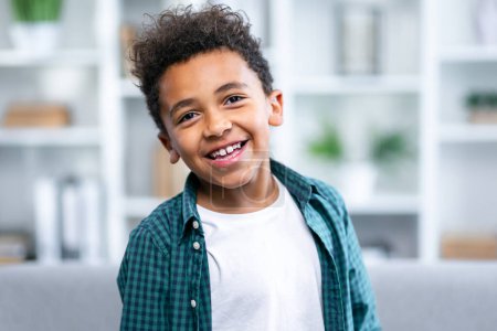 Foto de Niño sonriendo al retrato de la cámara, niño de raza mixta, sonrisa de niño étnicamente diversa en el interior - Imagen libre de derechos