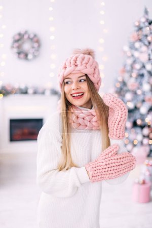 Photo for Girl in stylish winter clothes posing. close up. Christmas tree in a room with a fireplace. - Royalty Free Image