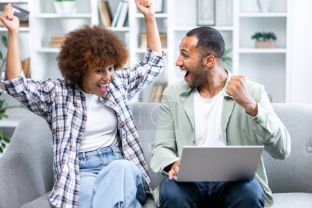 Photo for Couple of overjoyed friends using laptop computer, watching football game, sports betting, win money sitting on couch at home. Happy student reading test results, celebration success - Royalty Free Image