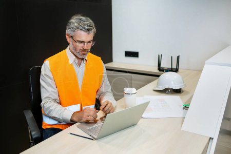 Photo for Automation engineers in safety vest using laptop for inspection and projects - Royalty Free Image