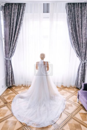 Photo for A bride in a chic dress stands with her back to the camera. - Royalty Free Image