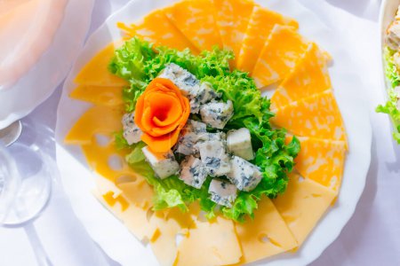 Photo for Top view of a plate with cheese slices and lettuce. different types of cheese. wedding banquet. - Royalty Free Image