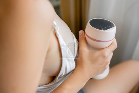 Téléchargez les photos : Le lait maternel dans le flacon de pompage électrique mis entre les mains de la mère - en image libre de droit