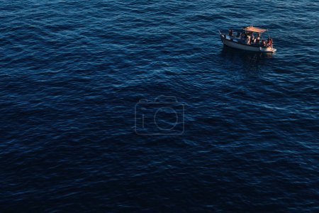 Téléchargez les photos : Bateau avec des touristes parmi la mer bleue. voyage en mer. ondulation sur l'eau de mer. - en image libre de droit