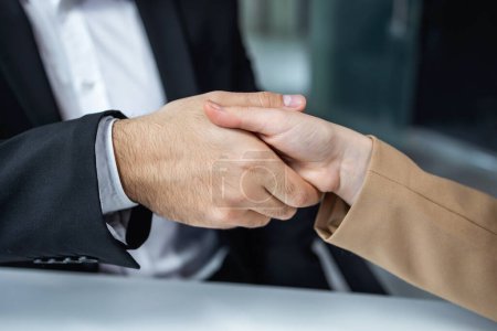 Photo for Man and woman in formal wear shake hands at office having successful deal about new business project. - Royalty Free Image