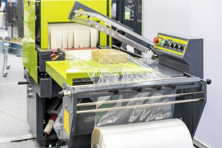 Boîte en carton sur table avec film plastique de film plastique rétrécir la machine d'emballage pour industrielle