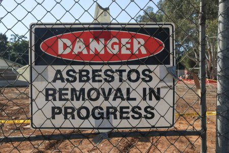 Foto de Retiro negro, blanco y rojo del asbesto del peligro en sitio de advertencia del progreso en cerca del alambre - Imagen libre de derechos