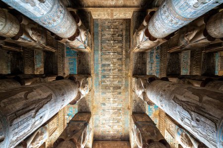Looking up at the ornately decorated columns and ceiling of the Temple of Hathor in Dendera, Egypt