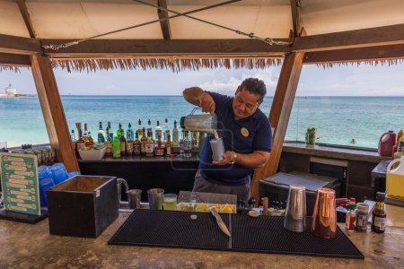 Téléchargez les photos : Close-up view of barman making cocktail in outdoor restaurant on coast of Atlantic Ocean. Oranjestad. Aruba. 01.30.2023. - en image libre de droit