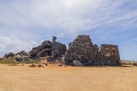 Téléchargez les photos : Vue panoramique des ruines de Bushiribana sur fond de nuages blancs. Île d'Aruba. - en image libre de droit