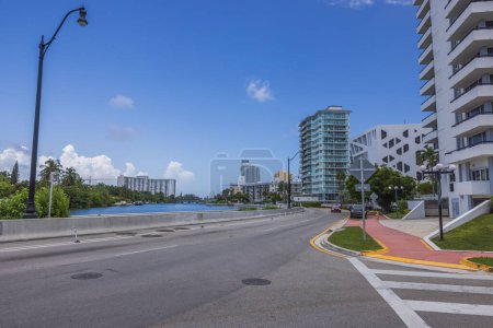 Téléchargez les photos : Beau paysage urbain de Miami Beach par une journée ensoleillée d'été. La route longe le front de mer avec de grands bâtiments modernes de l'autre côté. États-Unis. - en image libre de droit