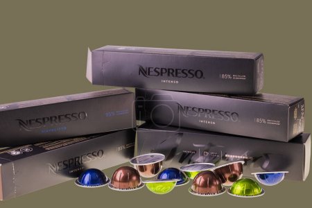 Foto de Vista de cerca de las cápsulas de café Nespresso con cajas de cartón aisladas sobre fondo verde-negro. - Imagen libre de derechos