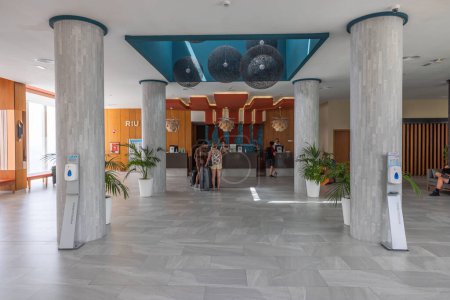 Foto de Vista del vestíbulo del hotel con zona de recepción donde los turistas se registran para alojarse en las habitaciones. Gran Canaria, España. - Imagen libre de derechos