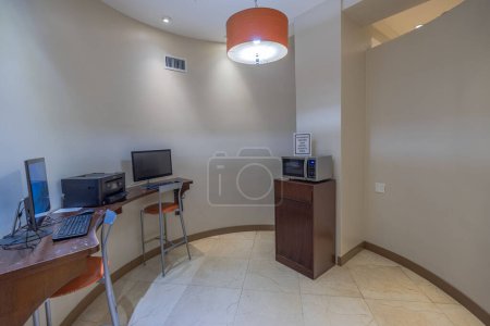 Photo for Contemporary hotel room interior featuring amenities such as computers, printer and microwave, designed for visitors on business trips. Miami Beach. USA. - Royalty Free Image