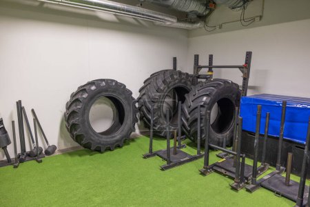Photo for Gym featuring oversized tires for strongman training and array of sports equipment, creating environment for dynamic and active workout. - Royalty Free Image