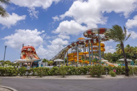 Photo for Scenic view of the hotel's water park featuring water slides, set against a backdrop of a blue sky with fluffy white clouds. - Royalty Free Image