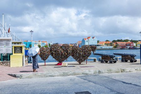 Téléchargez les photos : Belle vue de trois symboles de coeur installés sur la promenade de la baie Sainte Anna ornée d'écluses suspendues sur l'île de Curaçao. - en image libre de droit