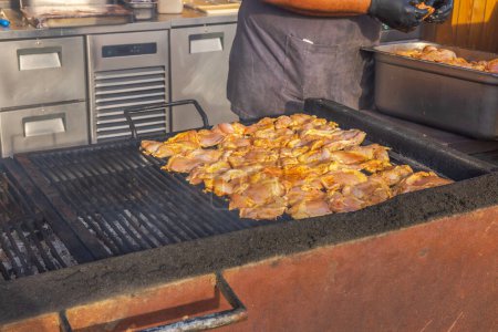 Téléchargez les photos : Plan rapproché du chef dans un restaurant extérieur, en plaçant un lot de viande fraîche sur le gril. Curaçao. - en image libre de droit