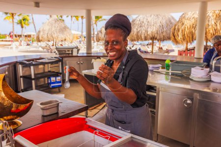 Photo for A smiling hotel restaurant worker holds a cup of ice cream prepared for a tourist - Royalty Free Image