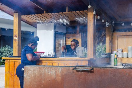 Téléchargez les photos : Vue rapprochée de deux serveurs afro-américains dans un restaurant barbecue en plein air. - en image libre de droit