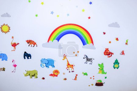 Hermosa vista de la pared en la habitación de los niños adornada con pegatinas de pequeñas figuras de animales lindo.