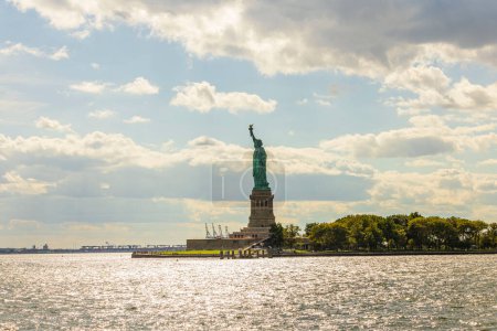 Hermosa vista de la Estatua de la Libertad en la Isla de la Libertad en el río Hudson con el telón de fondo de un cielo azul con nubes blancas. Estados Unidos.