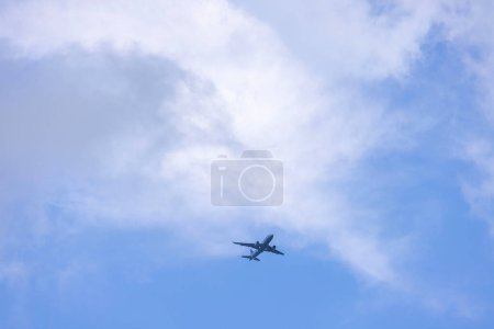 Airplane descending against the backdrop of a blue sky with white clouds. USA.