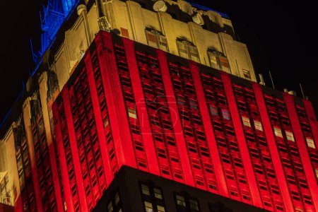 Téléchargez les photos : Belle vue de nuit sur le bâtiment éclairée par des lumières rouges, jaunes et bleues éclatantes. New York, États-Unis. - en image libre de droit