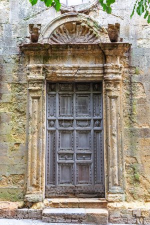 Vista de la antigua puerta medieval de una antigua iglesia de piedra. Vertical. 