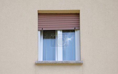 Téléchargez les photos : Maison d'habitation protégée par un volet métallique devant une fenêtre - en image libre de droit