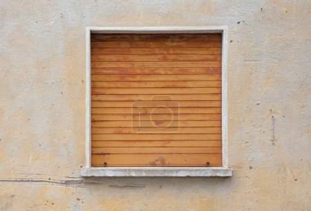 Téléchargez les photos : Maison d'habitation protégée par un volet métallique devant une fenêtre - en image libre de droit
