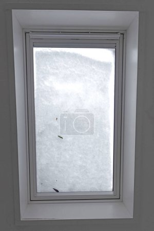 Téléchargez les photos : Vue à travers la fenêtre du toit couverte de neige fondue de l'intérieur du bâtiment, mise au point sélective - en image libre de droit