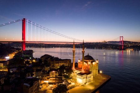 Foto de ORTAKOY, ISTANBUL, TURQUÍA. Vista aérea de Estambul. Vista del amanecer de la mezquita Ortakoy y del puente del Bósforo (puente de los mártires del 15 de julio). Disparo de dron. - Imagen libre de derechos