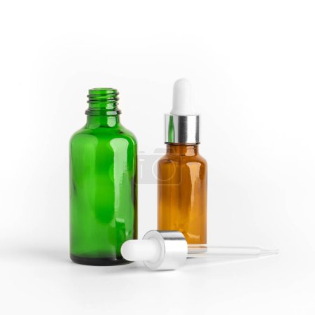 Foto de Botella cosmética de vidrio de color de aceite esencial con gotero o pipeta aislada sobre fondo blanco. Botella redonda con DropperStop. - Imagen libre de derechos