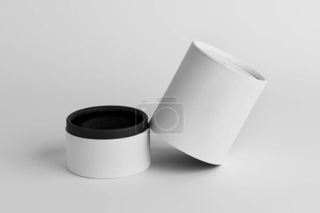 Téléchargez les photos : Boîte recouverte de papier blanc. Boîte de parfum en forme de cylindre. Conception de maquette de boîte. - en image libre de droit