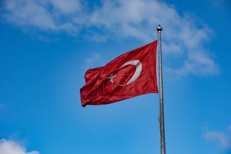 Bandera turca ondeando en cielo azul.