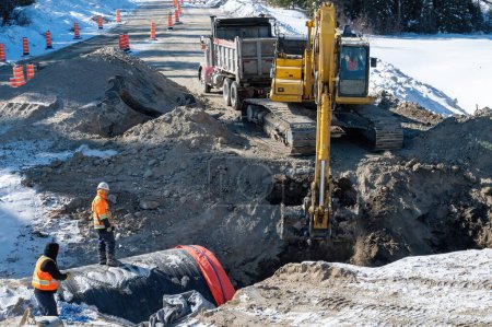 Foto de Trabajos de excavación para la sustitución de una alcantarilla en una carretera durante el invierno - Imagen libre de derechos
